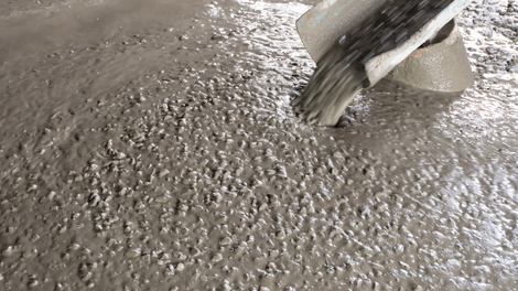 A large concrete structure is being built in a parking lot.