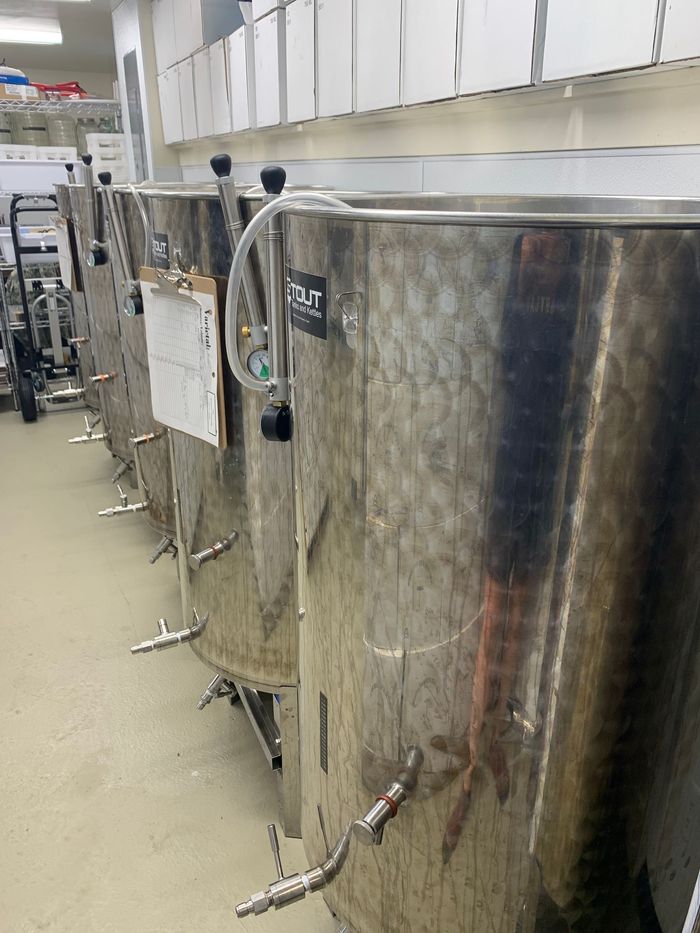 A row of stainless steel tanks are lined up