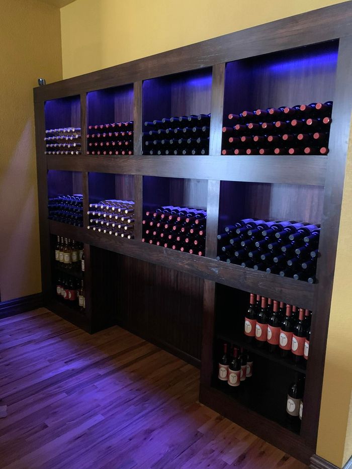 A shelf filled with lots of bottles of wine