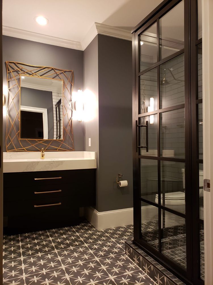 Modern powder room with dark gray walls, black vanity, and patterned tile floor.