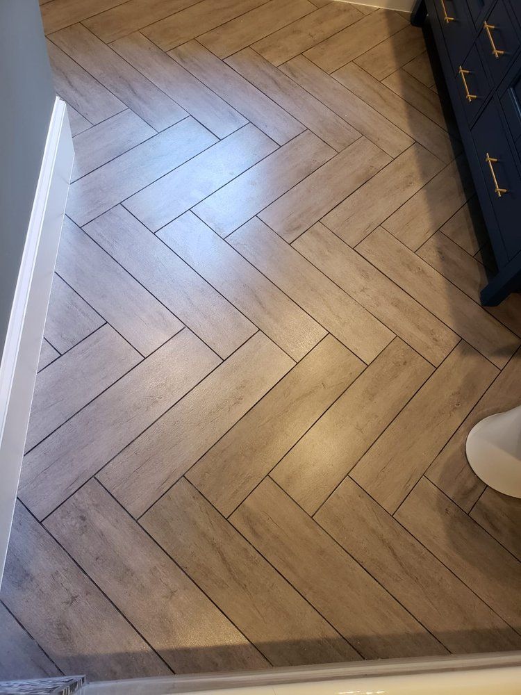 Herringbone pattern floor tiles in a bathroom, beige color.