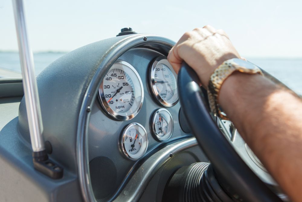 A Person Is Driving A Boat With A Watch On Their Wrist — HiTune Marine In Mareeba, QLD