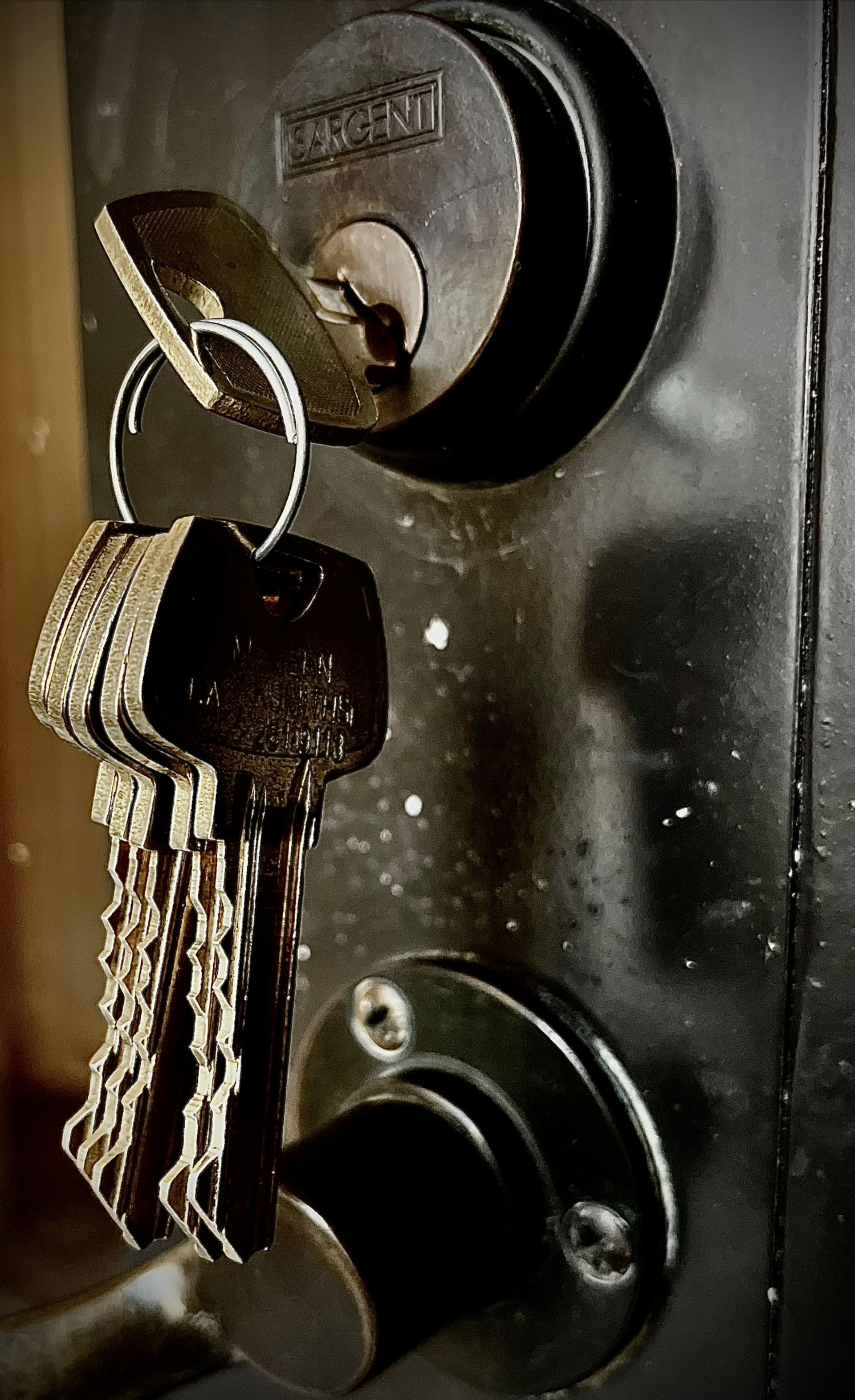 Key bunch in a dark, metallic lock, likely for a door.