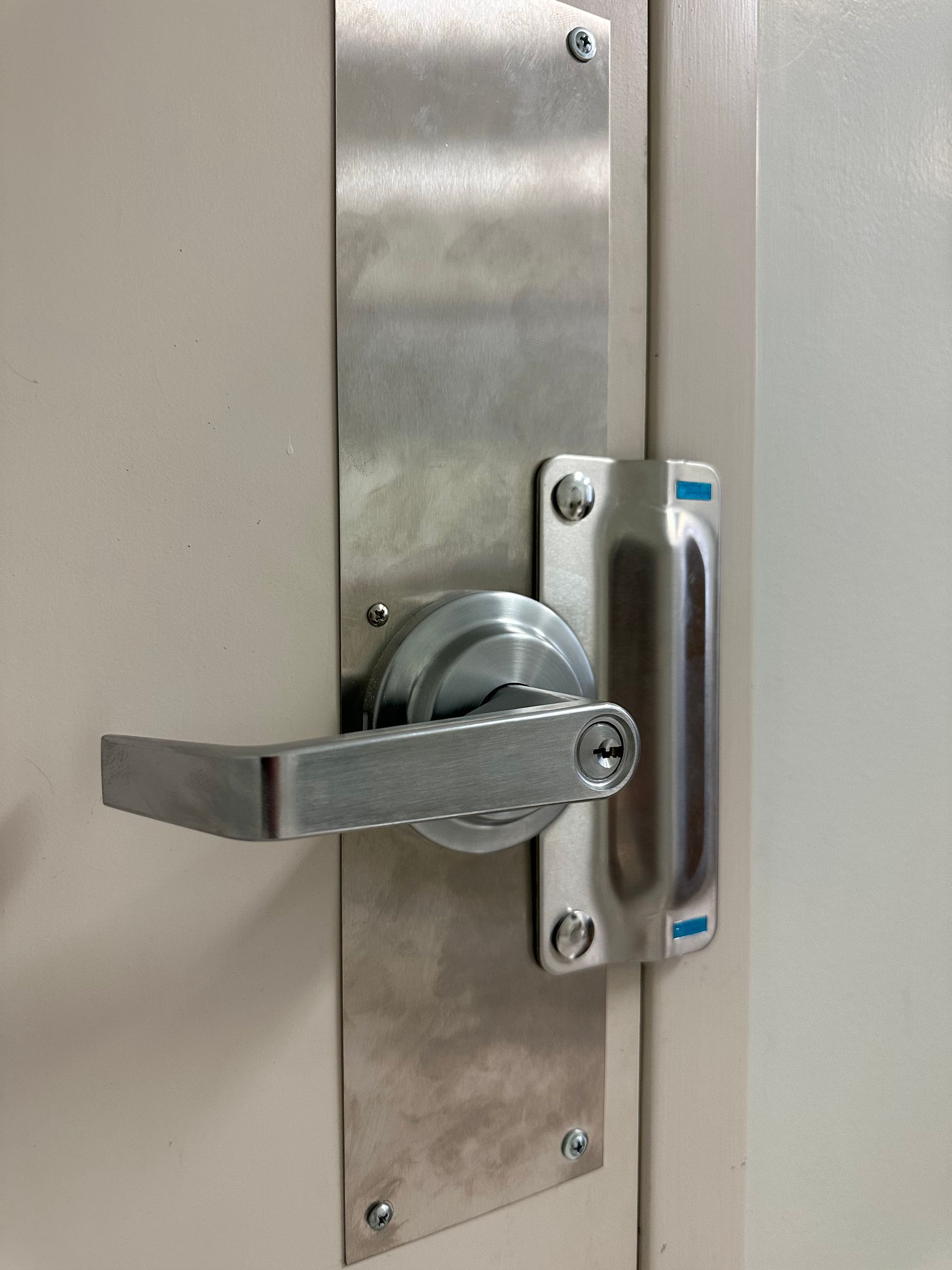 A door bolstered with a heavy duty commercial grade lock and latch protector.