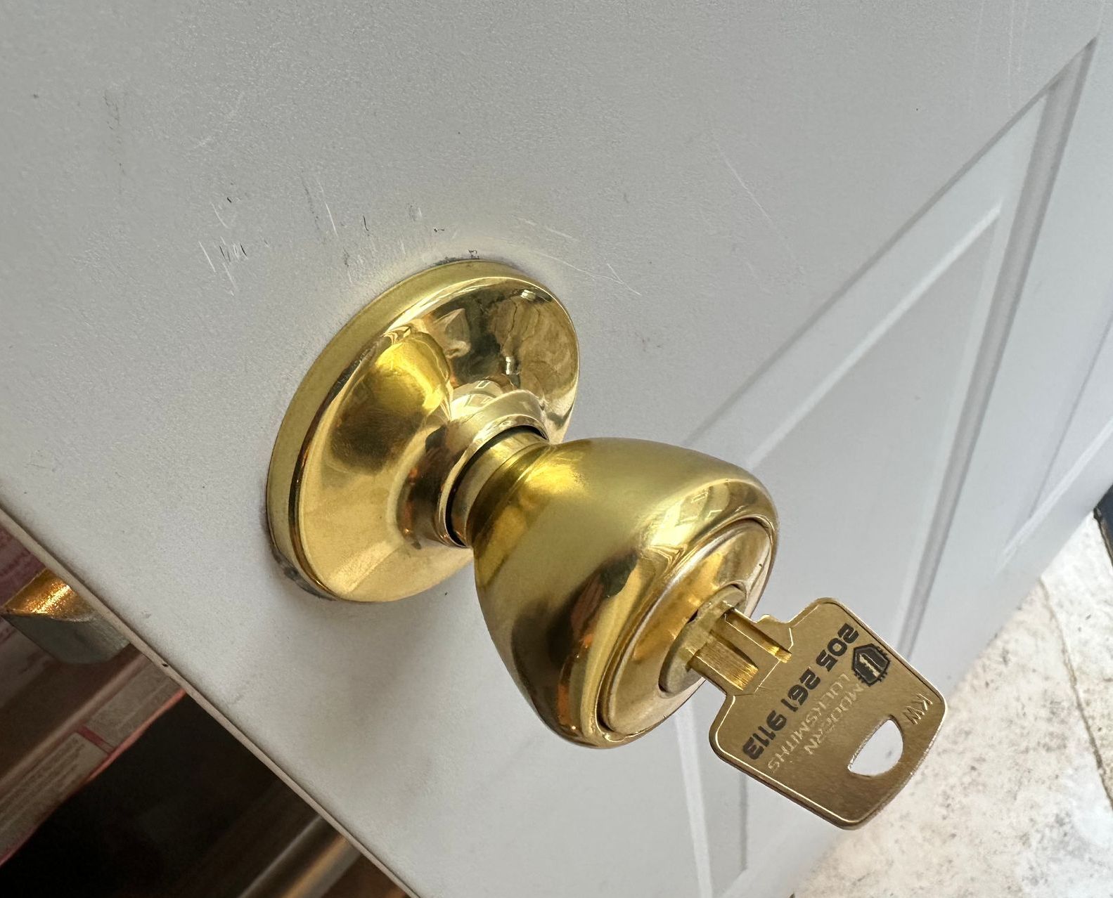 A brass door knob with a key in it