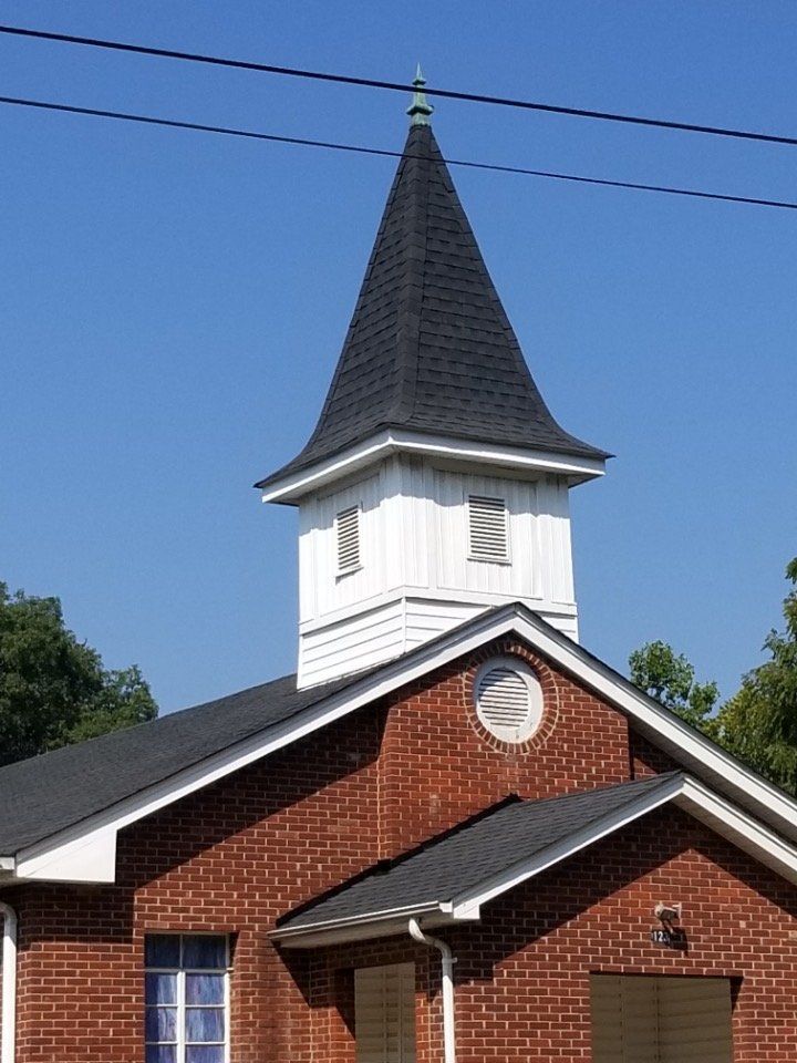 A brick church with a steeple on top of it