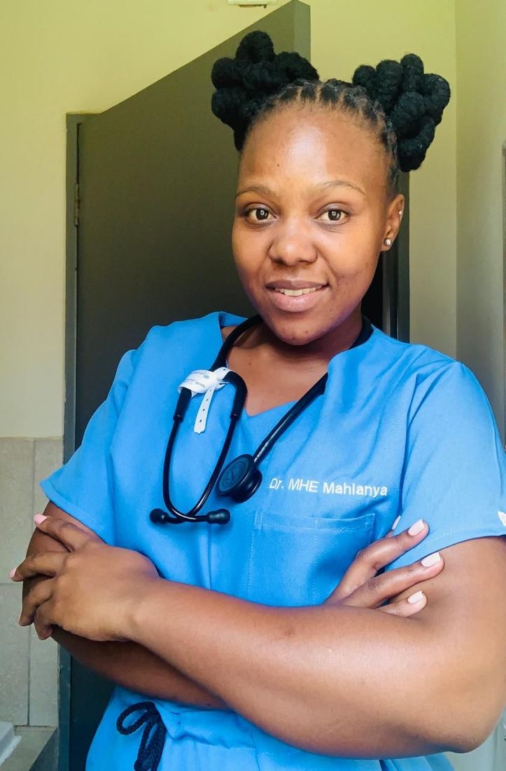 A nurse with a stethoscope around her neck has her arms crossed