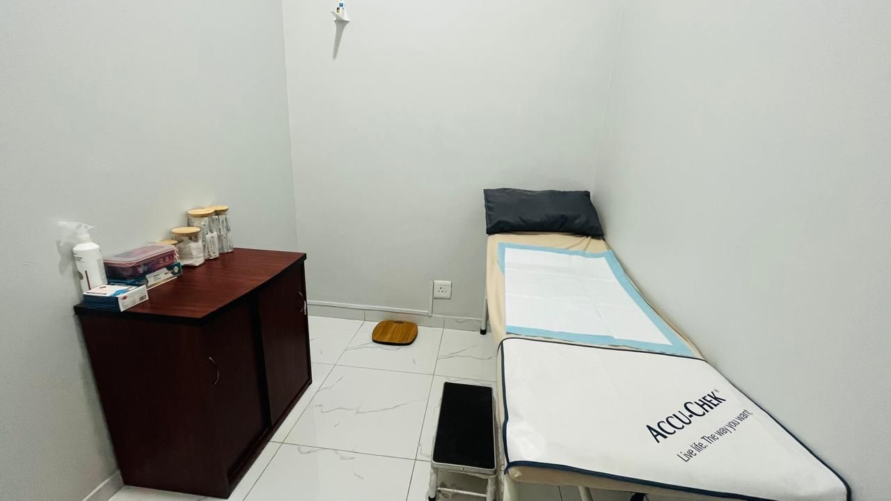 A doctor 's office with a bed and a cabinet.