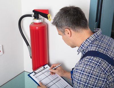 Garage Fire Extinguishers — Worker Checking On A List Of Fire Extinguisher In Keswick, VA