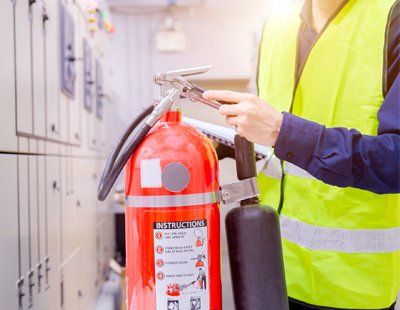 Oil File Extinguishers — Worker Checking On The Pin Of Fire Extinguisher In Keswick, VA