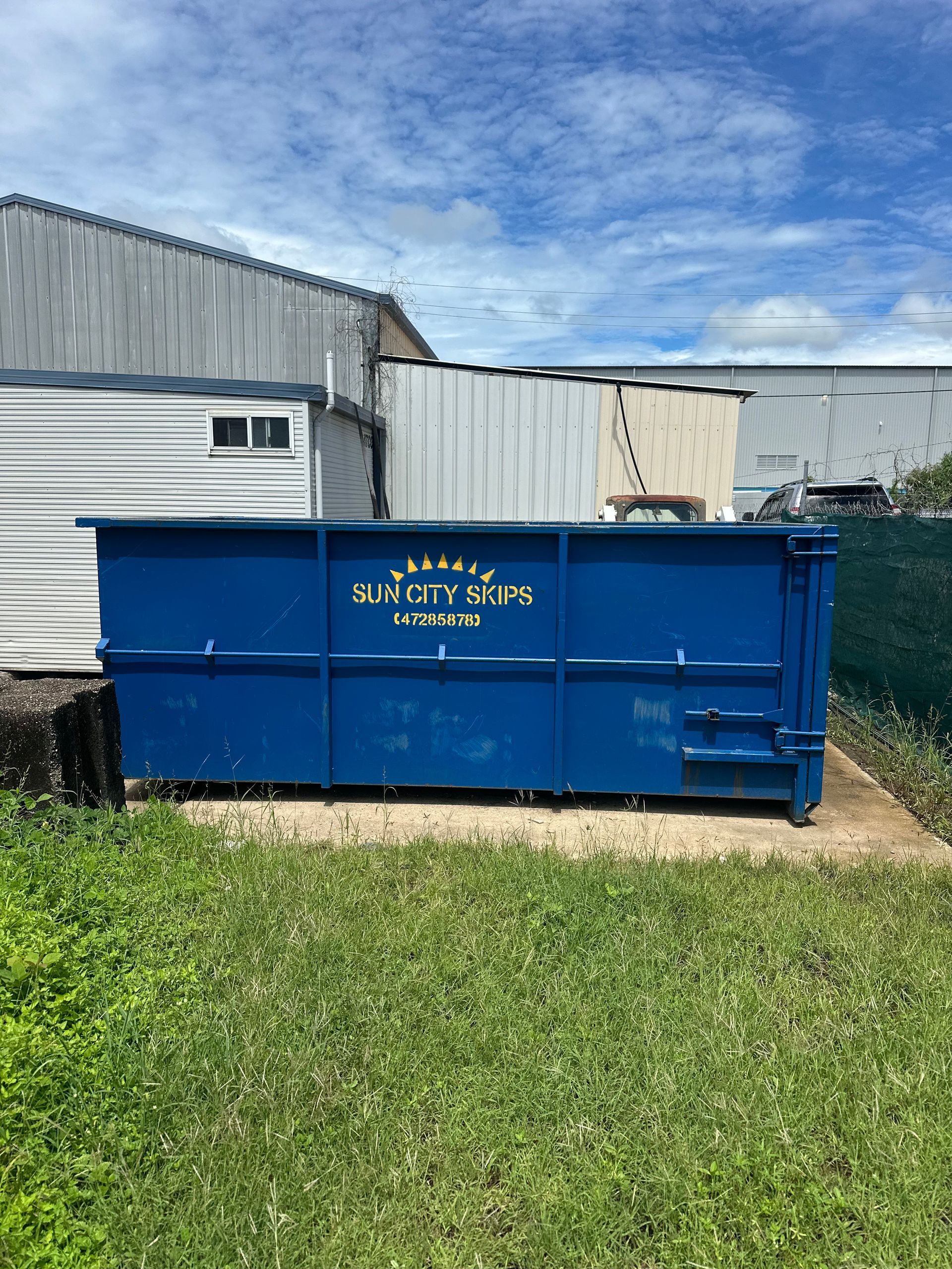 A Red Dumpster Filled With Branches And Leaves — Sun City Skips In Bohle, QLD