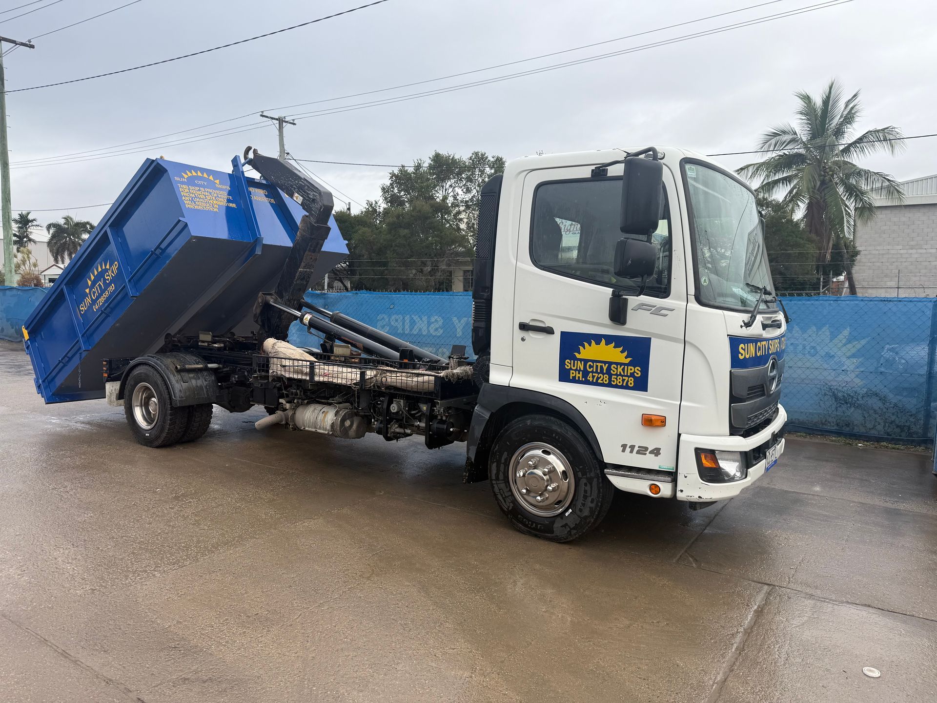 A Dump Truck Is Being Loaded With Garbage In A Warehouse — Sun City Skips In Bohle, QLD