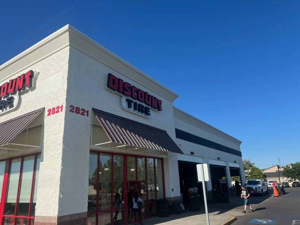 A discount tire store with cars parked in front of it