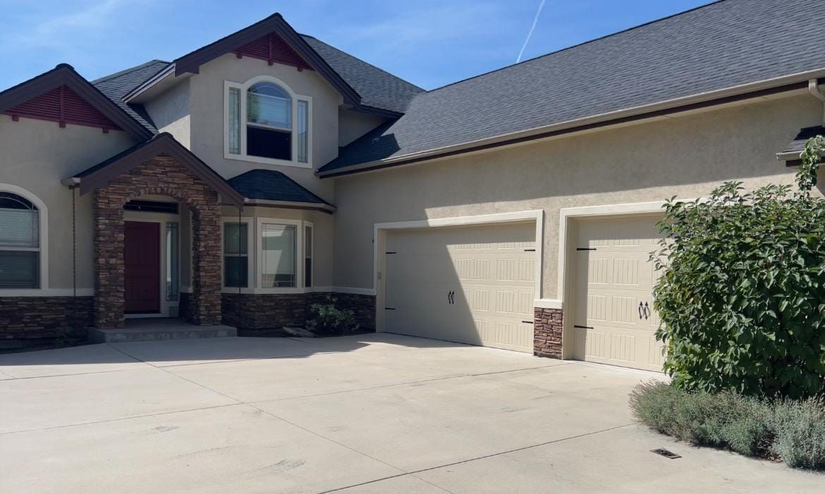 A large house with two garage doors and a driveway