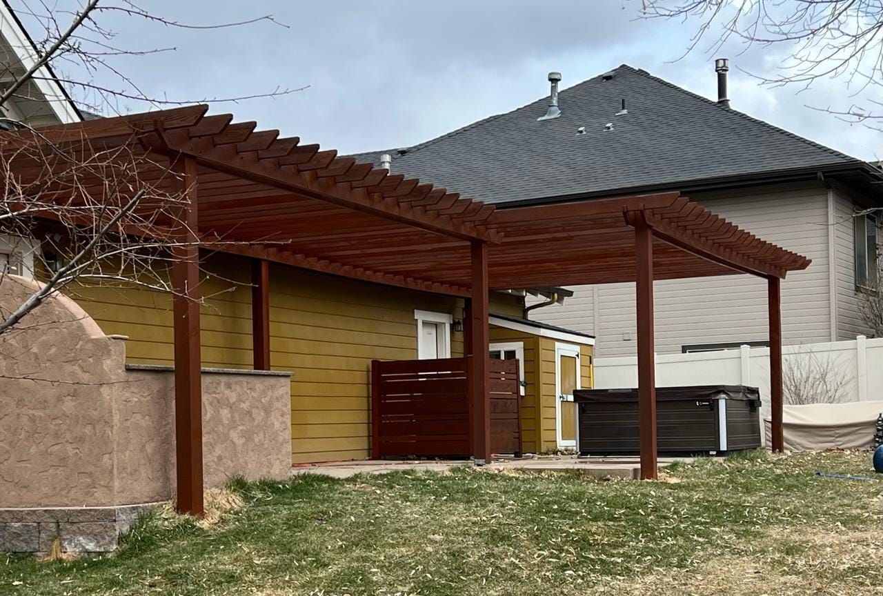 There is a pergola in the backyard of a house.