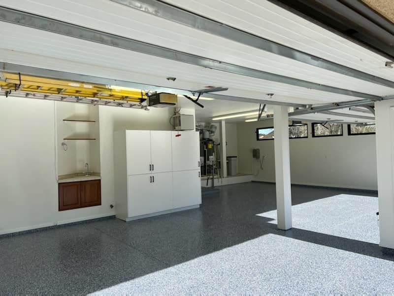 An empty garage with a ladder hanging from the ceiling
