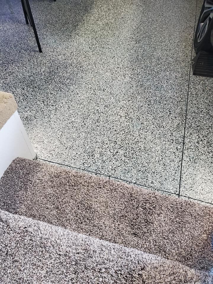 A close up of a carpeted floor next to stairs.
