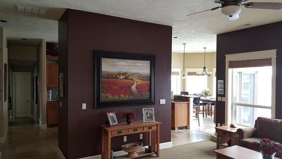 A living room with a painting on the wall and a ceiling fan
