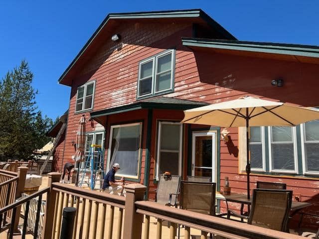 A red house with a deck and umbrellas in front of it