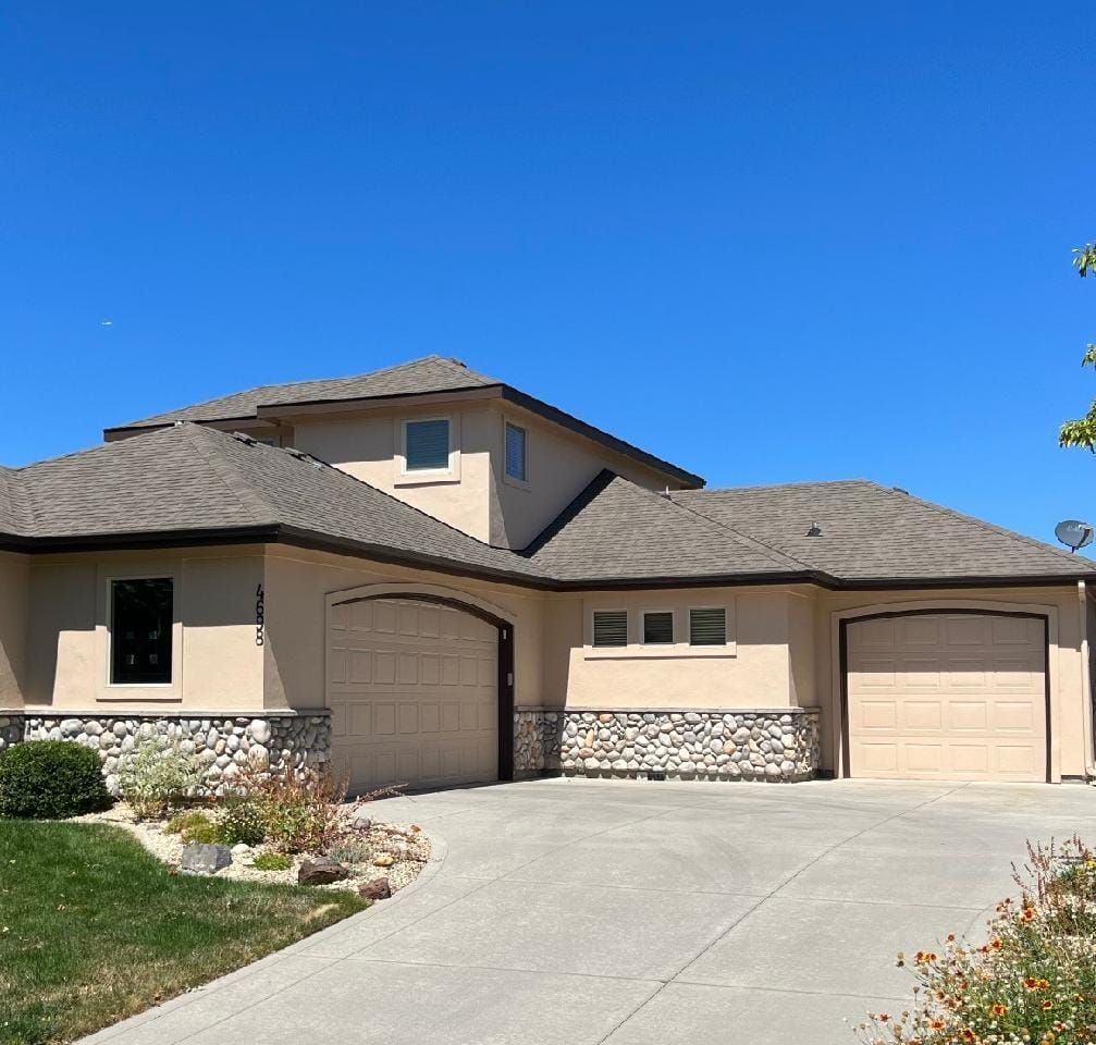 A large house with two garage doors and a driveway