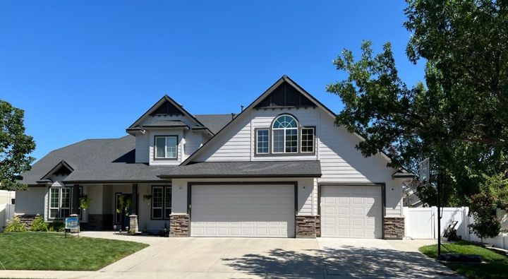 A large white house with a gray roof is for sale