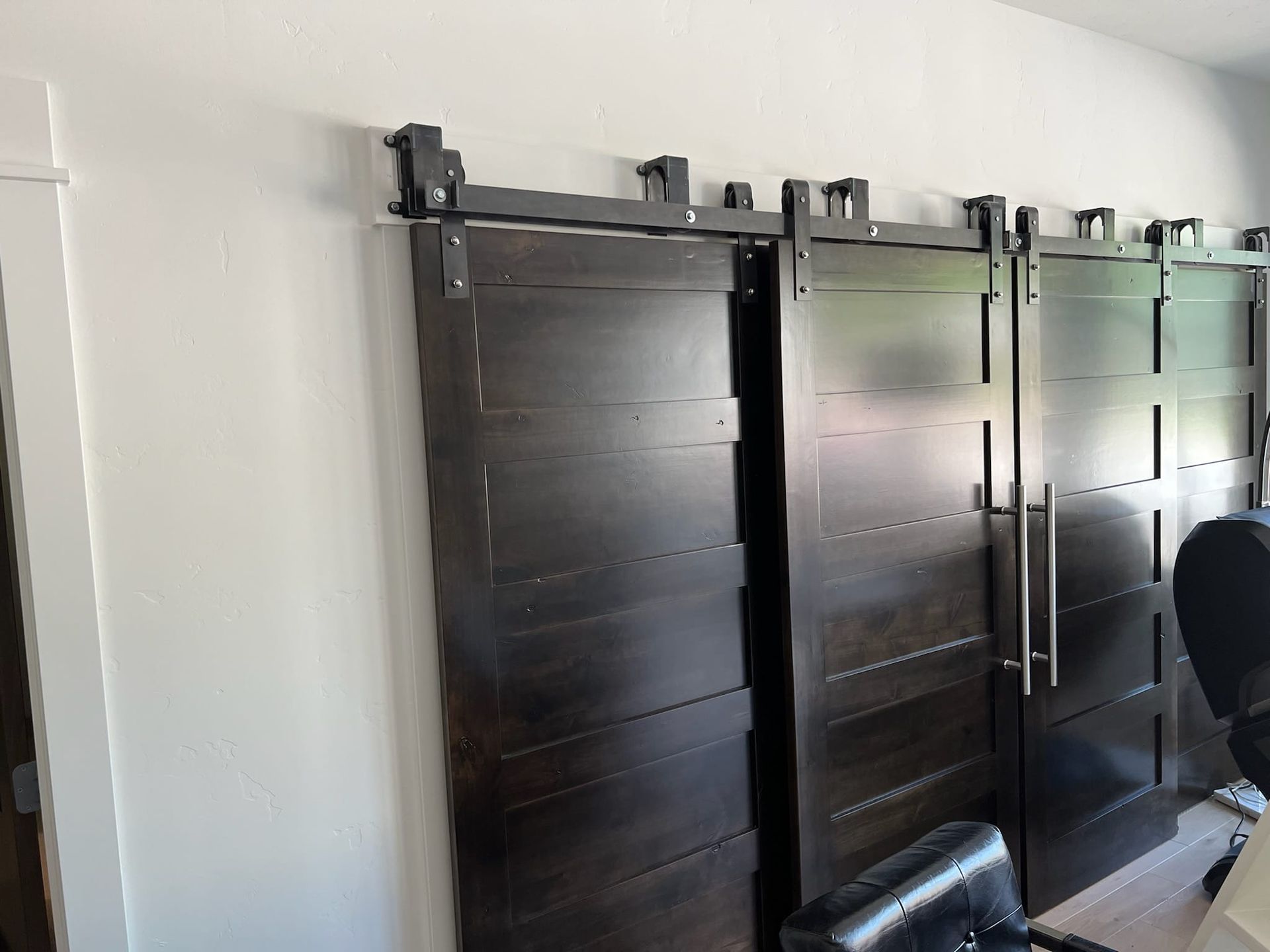 Three sliding barn doors are hanging on a wall in a room.