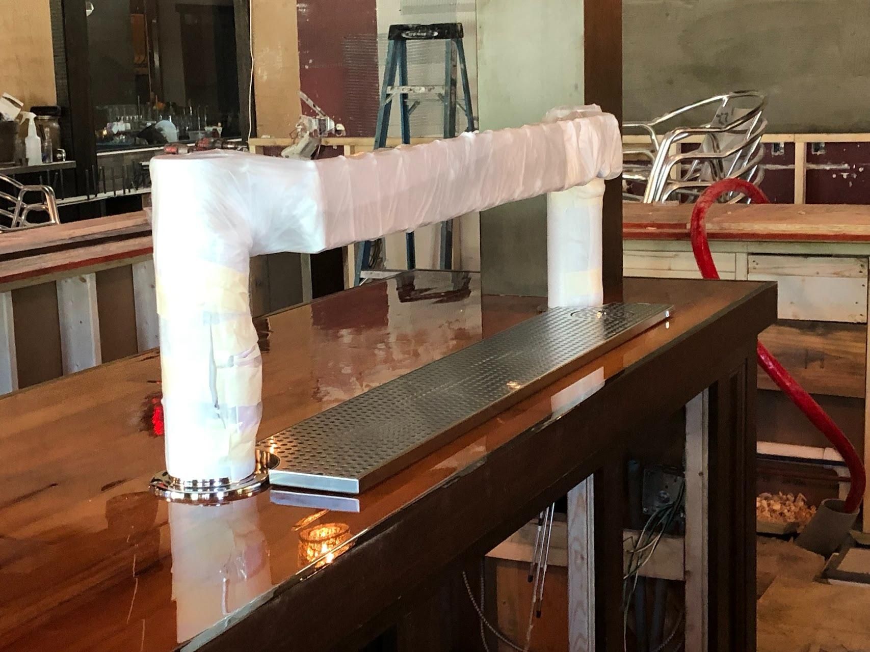 A wooden table with a metal bar on top of it