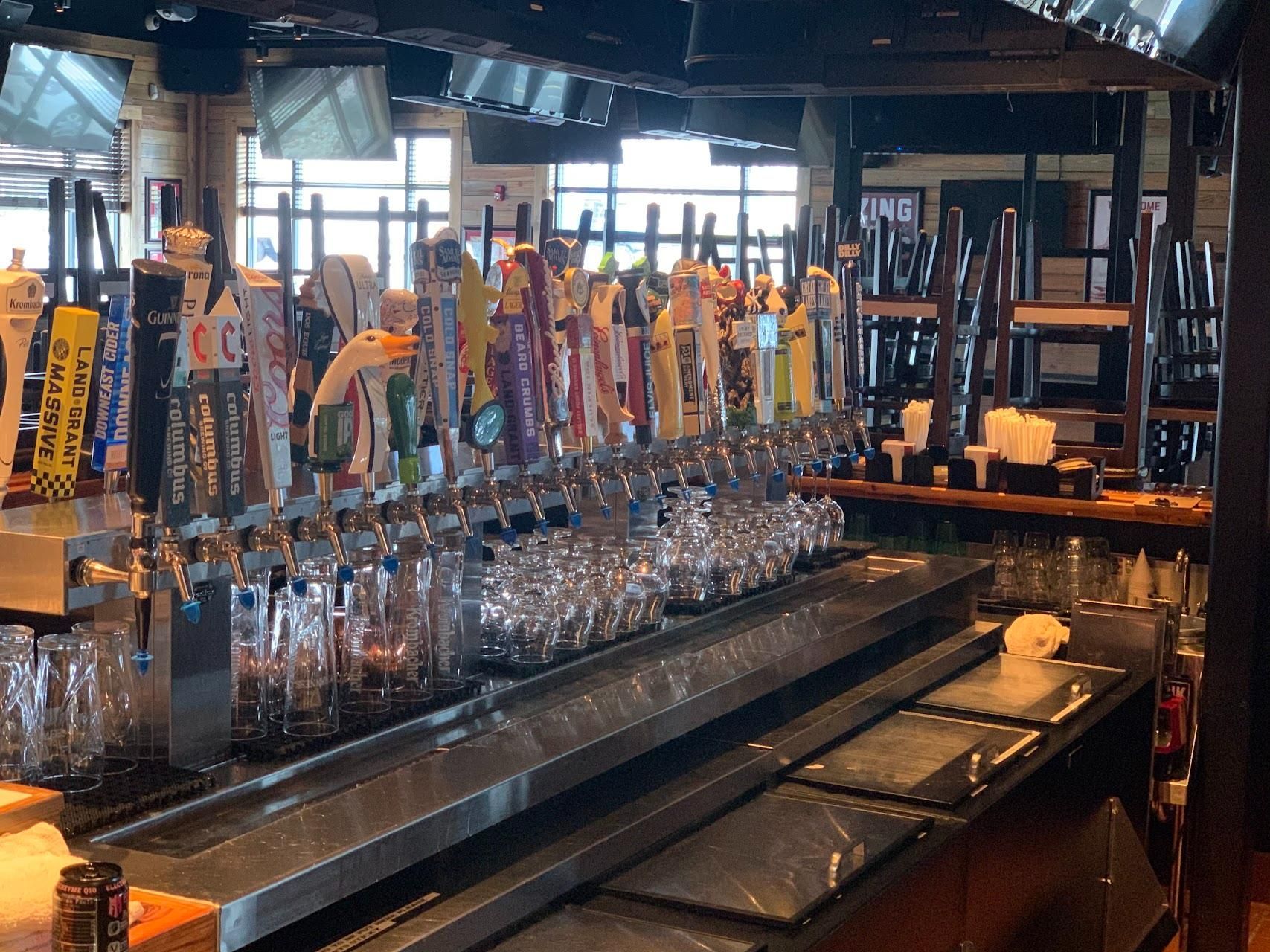 A bar filled with lots of beer taps and glasses.