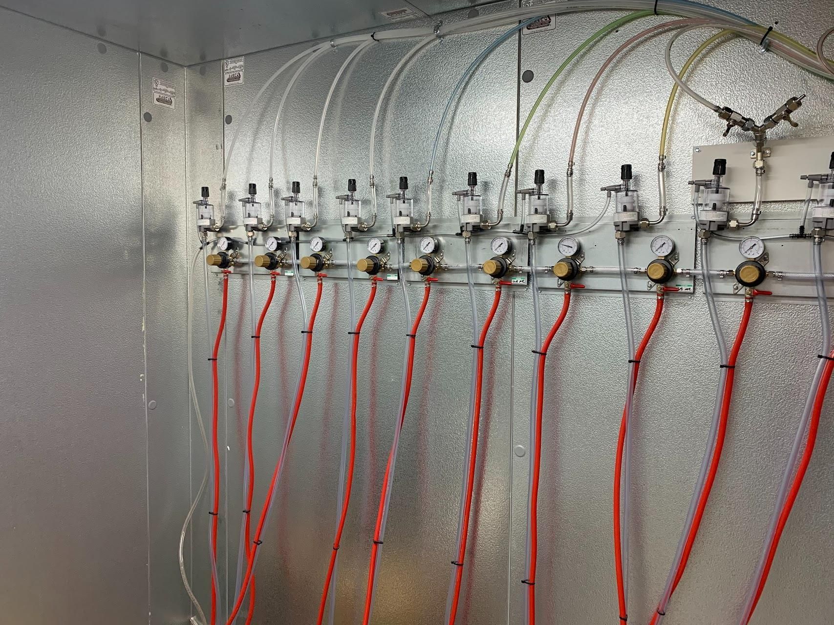 A wall with a bunch of wires and valves on it