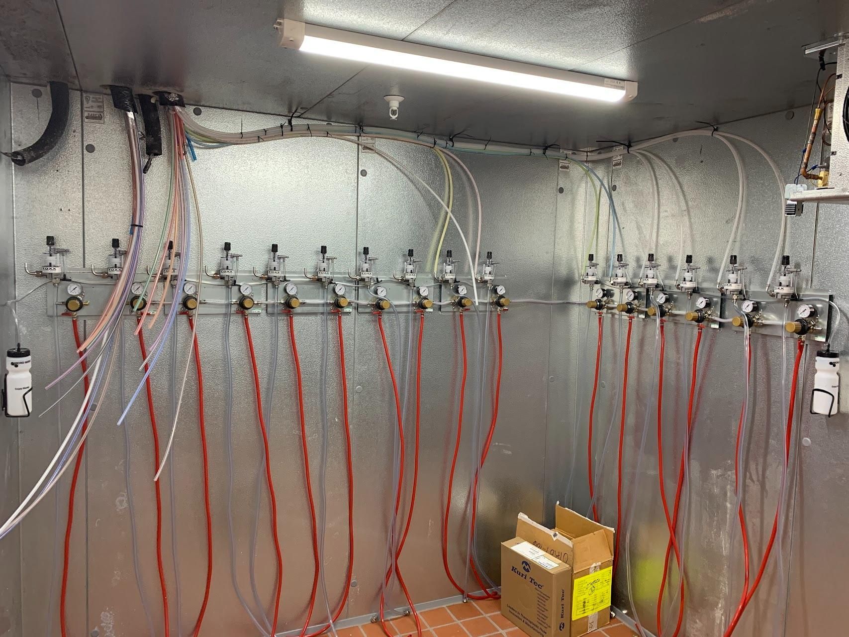 A room with a lot of wires hanging from the ceiling and a box on the floor.