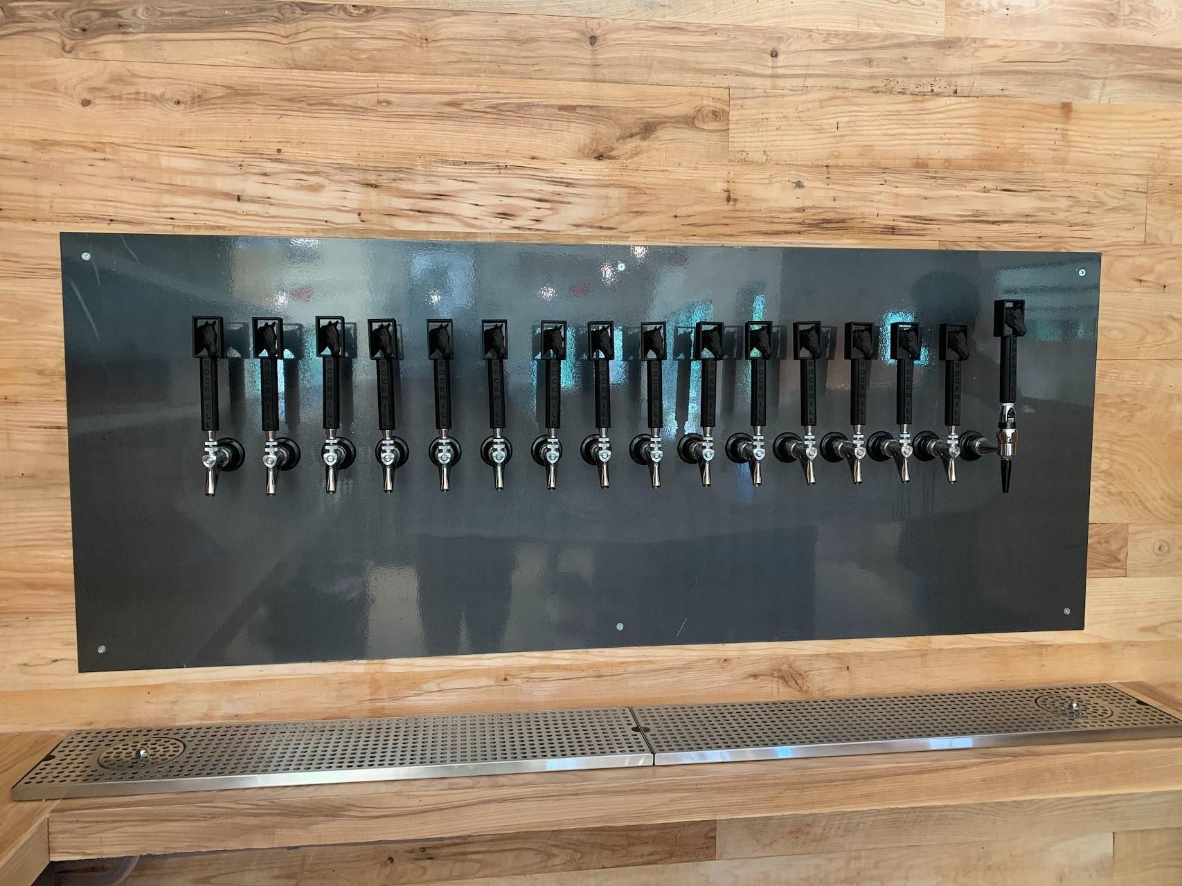 A row of taps hanging on a wooden wall