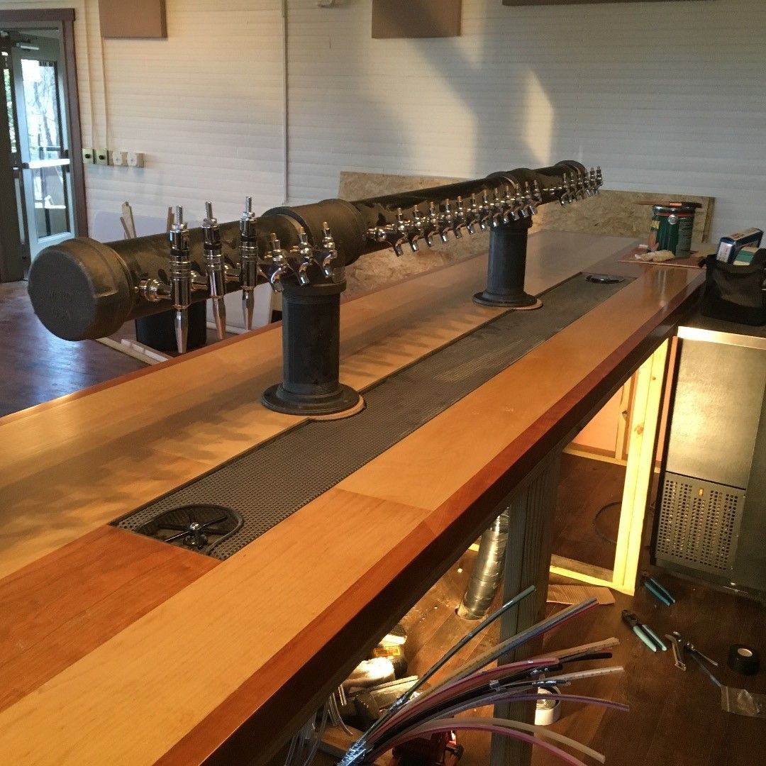 A row of beer taps on a wooden bar