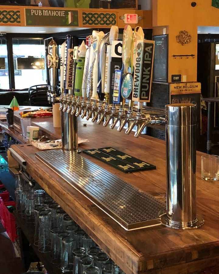 A bar with a lot of beer taps including one that says punk ipa