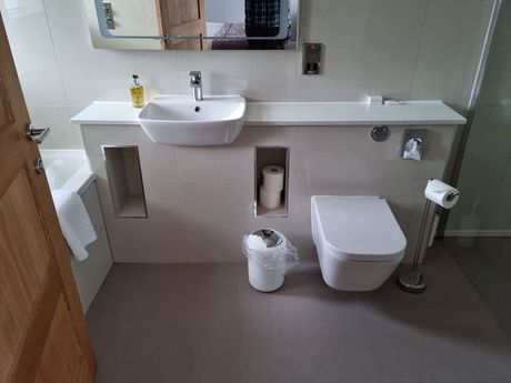 Bathroom installation with a toilet, sink, bath, and shower.