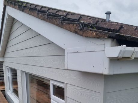 White Fascia boards and gutters on a grey house.