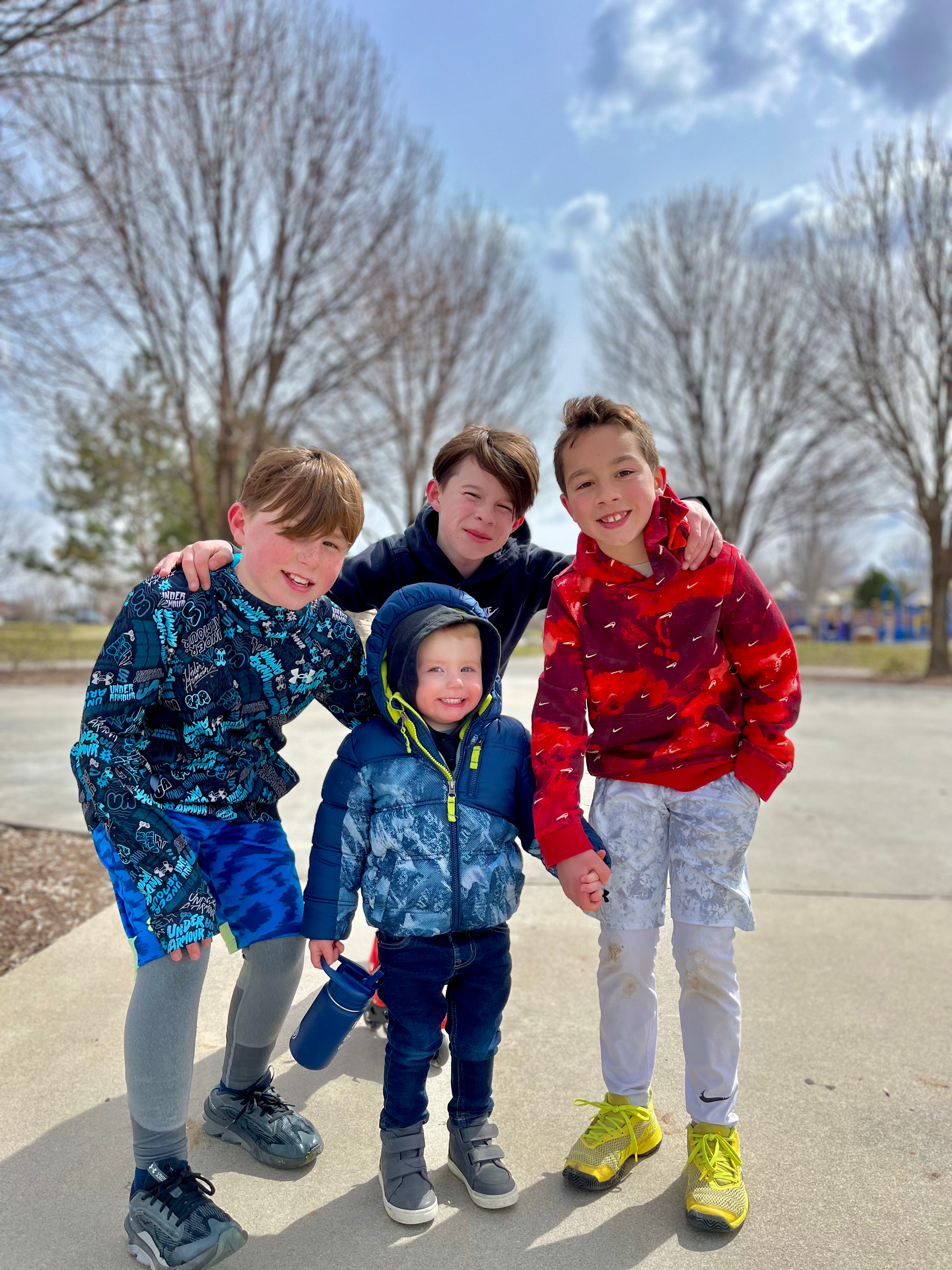 A group of young boys are posing for a picture on a sidewalk.
