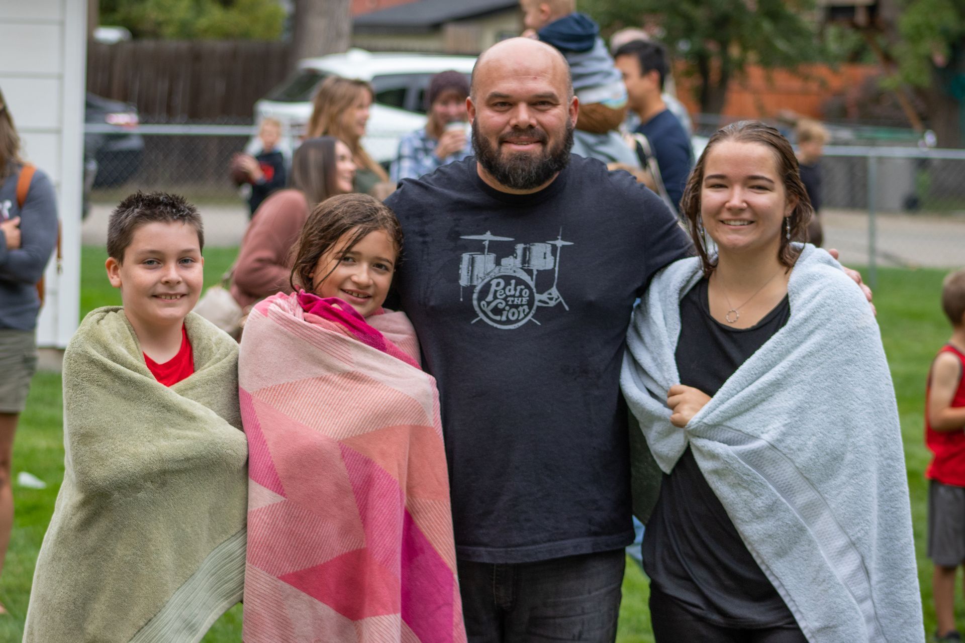 A group of people wrapped in blankets are posing for a picture.