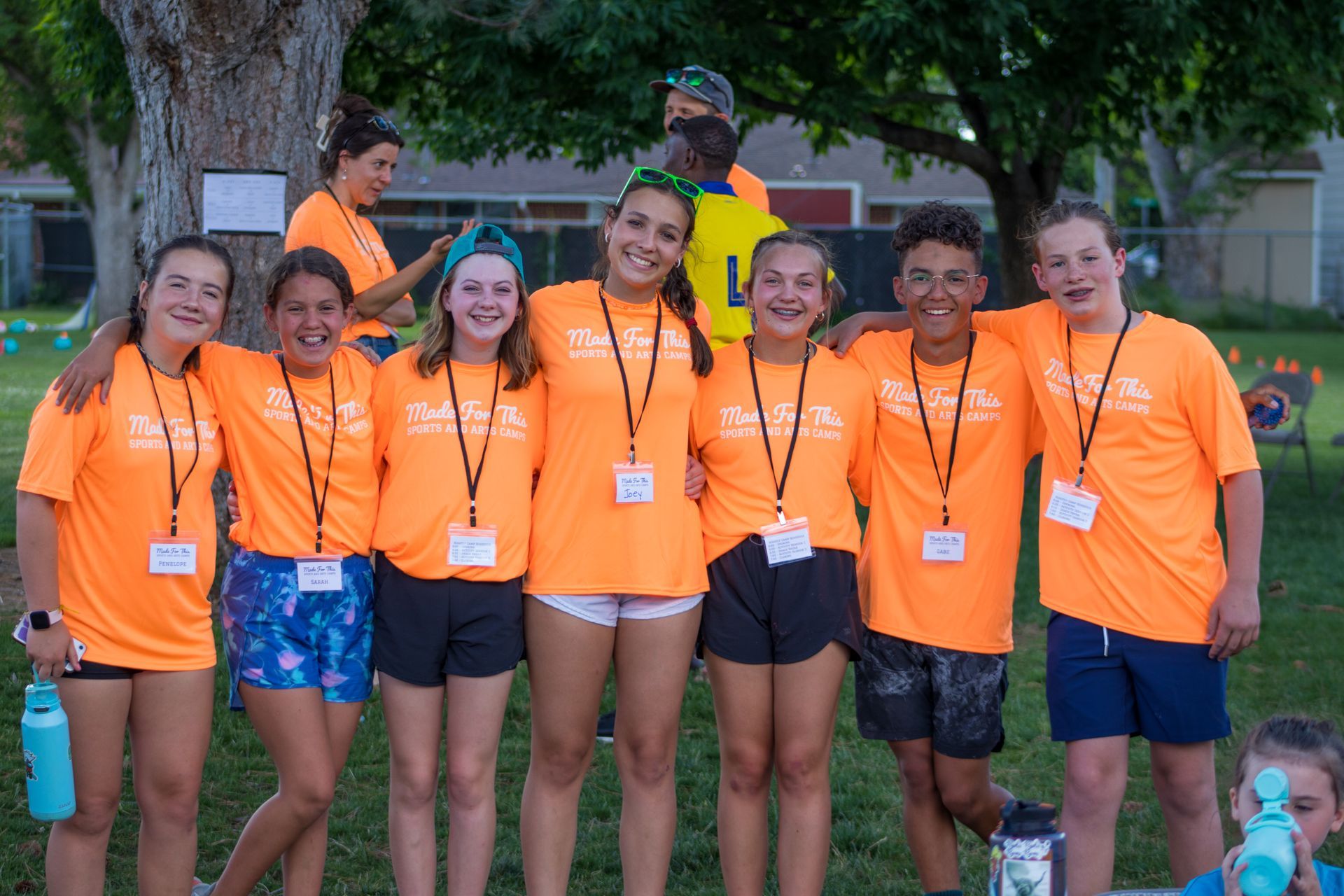 A group of young people wearing orange shirts are posing for a picture.