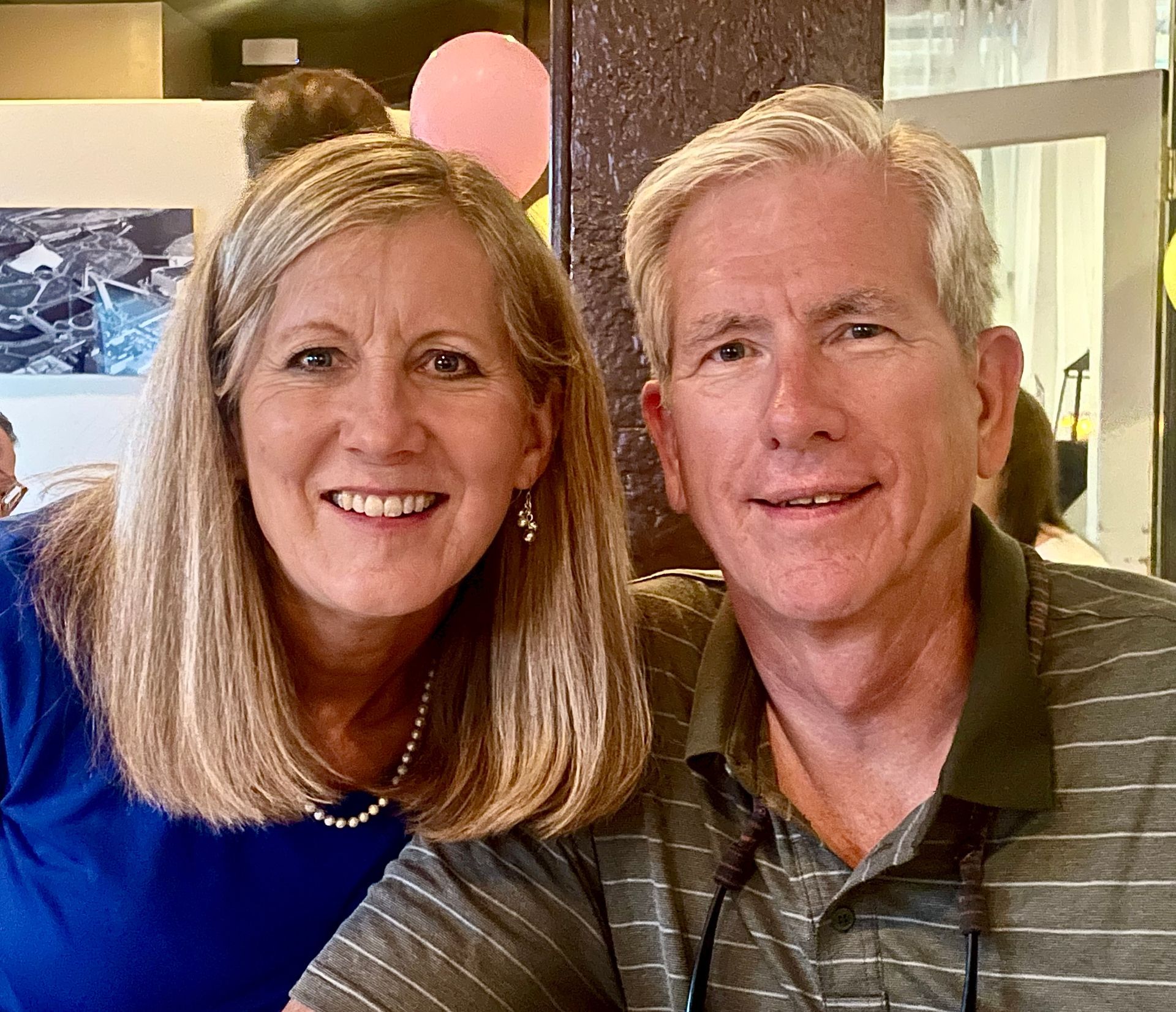 A man and a woman are posing for a picture together and smiling.