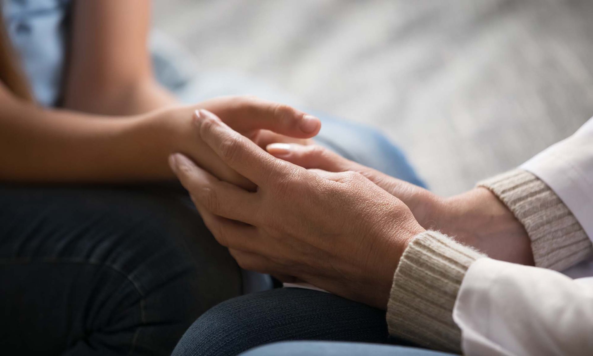 A close up of a person holding another person 's hand.