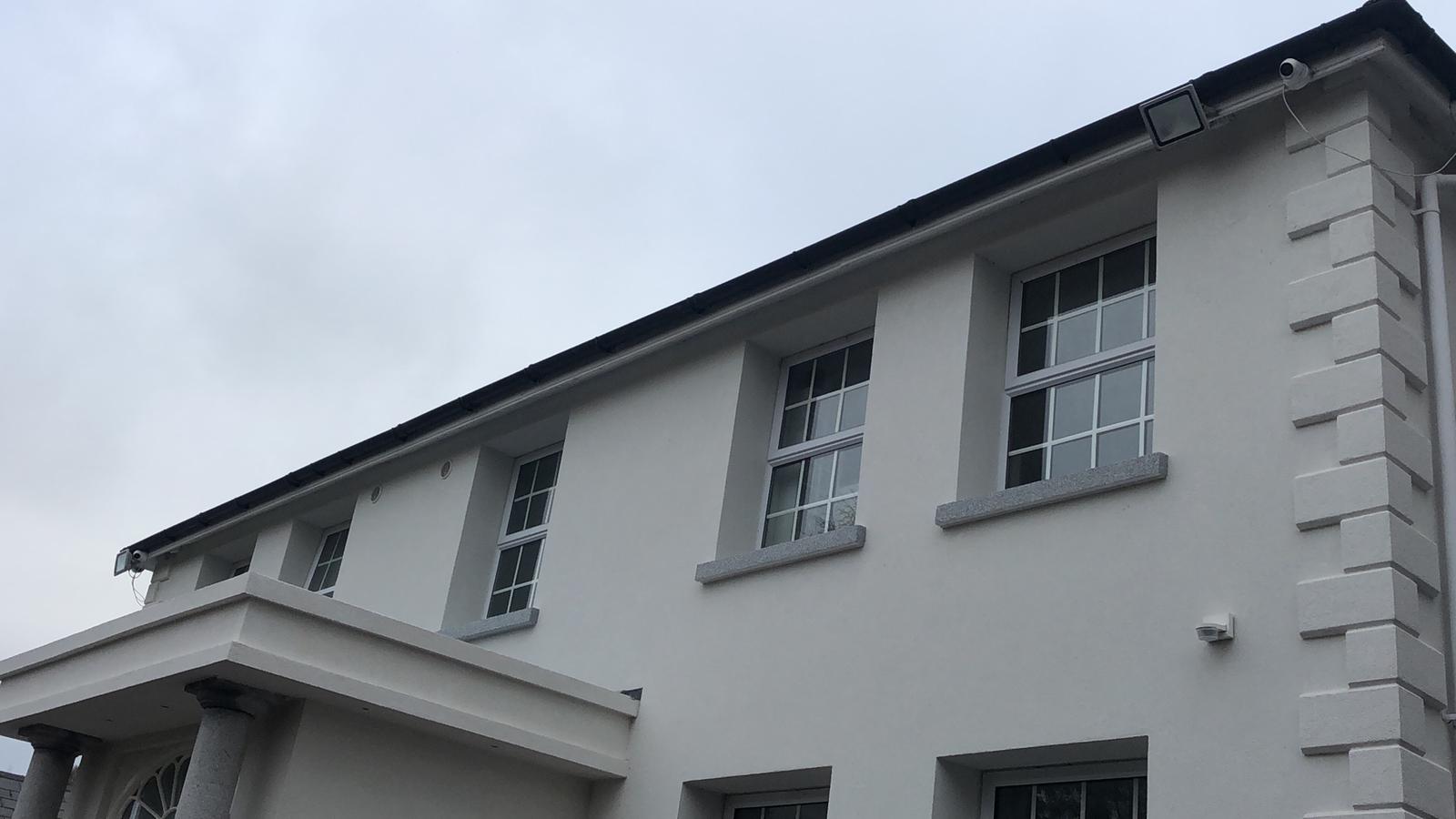 A large white building with a black roof and a lot of windows.