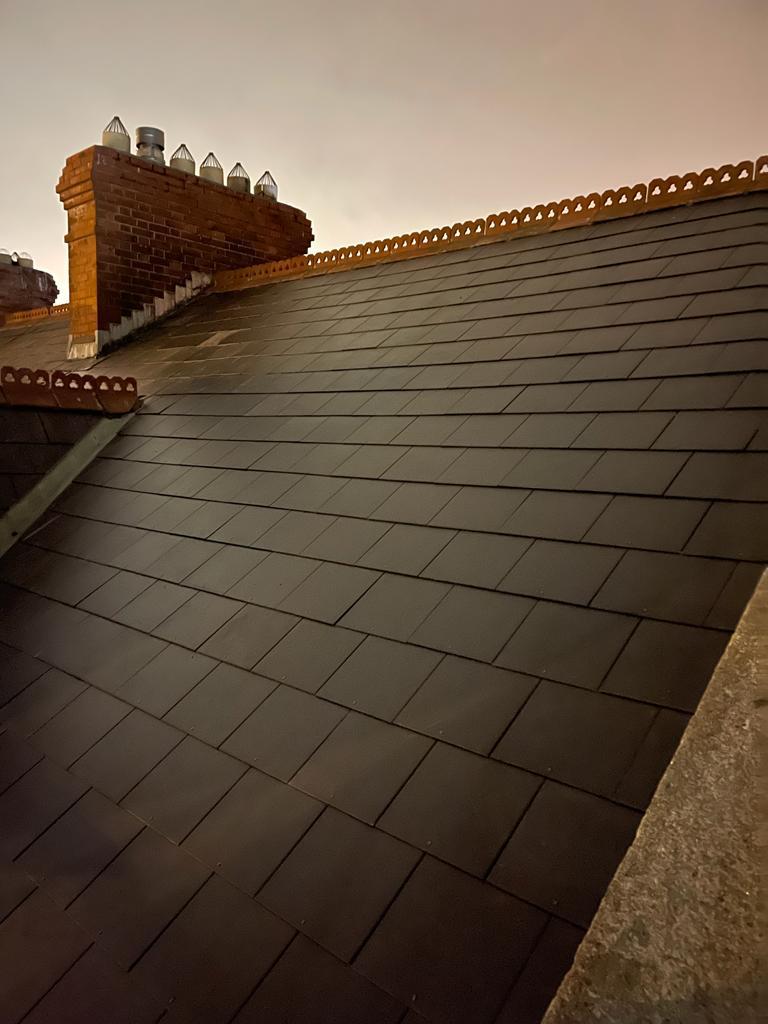 A close up of a roof with a chimney on top of it.