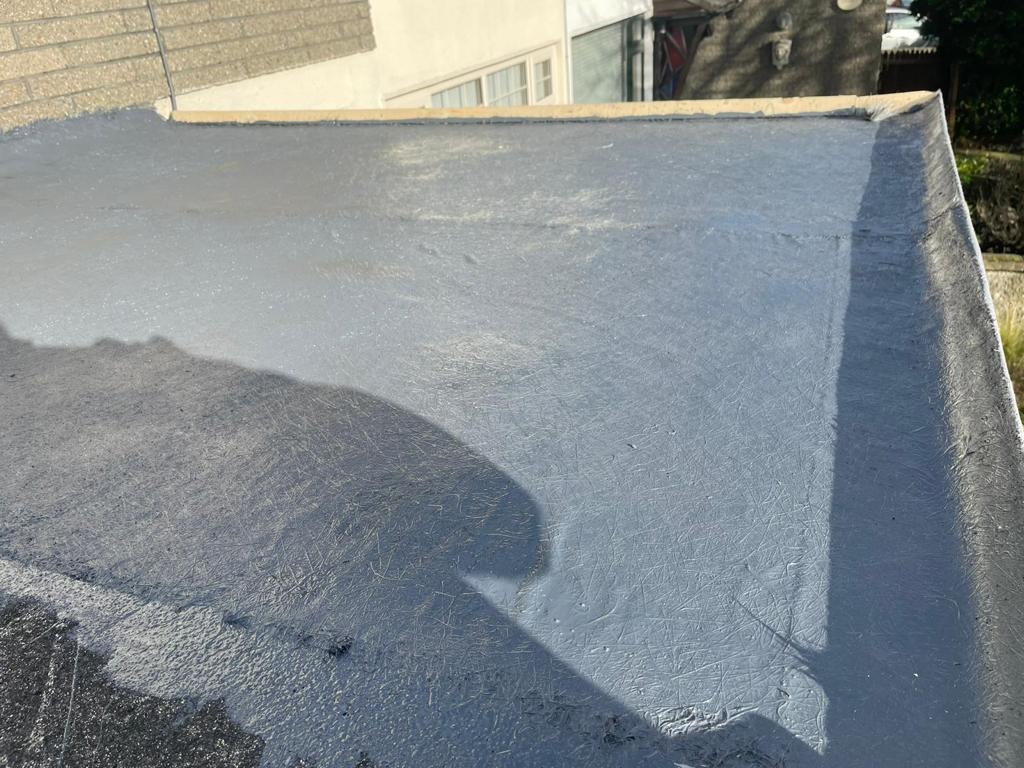 A close up of a roof with a shadow of a person on it.