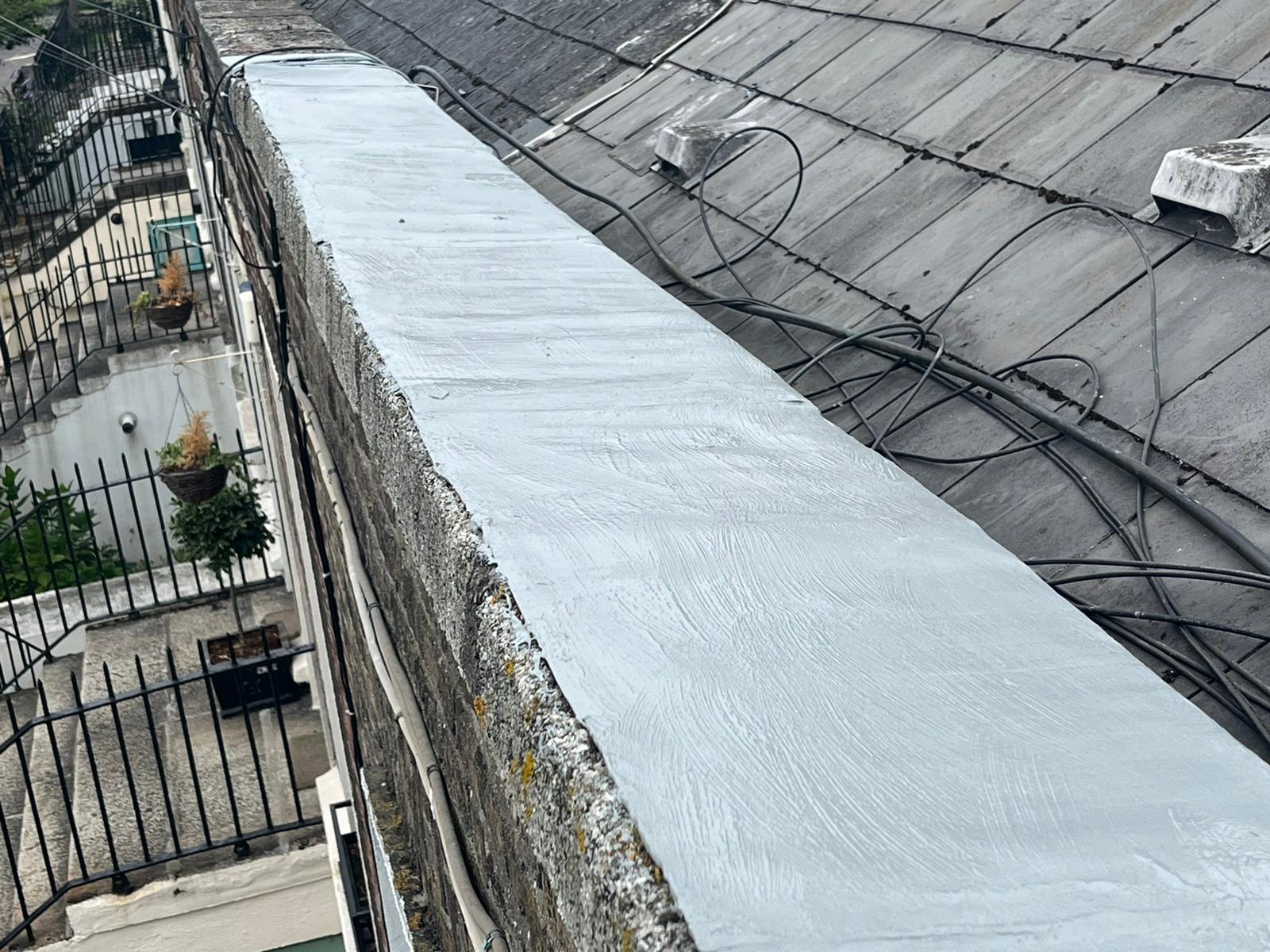 A roof with a concrete ledge on top of it.