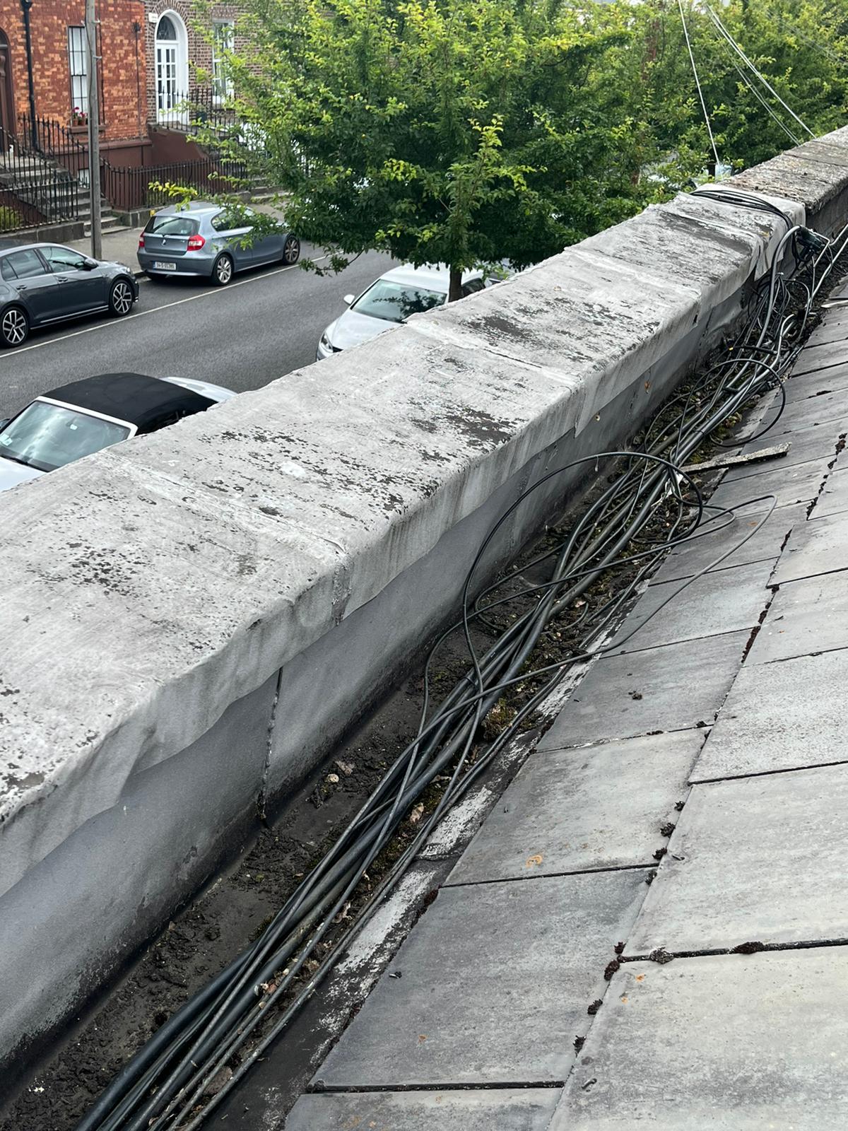 A concrete wall with a lot of wires coming out of it.