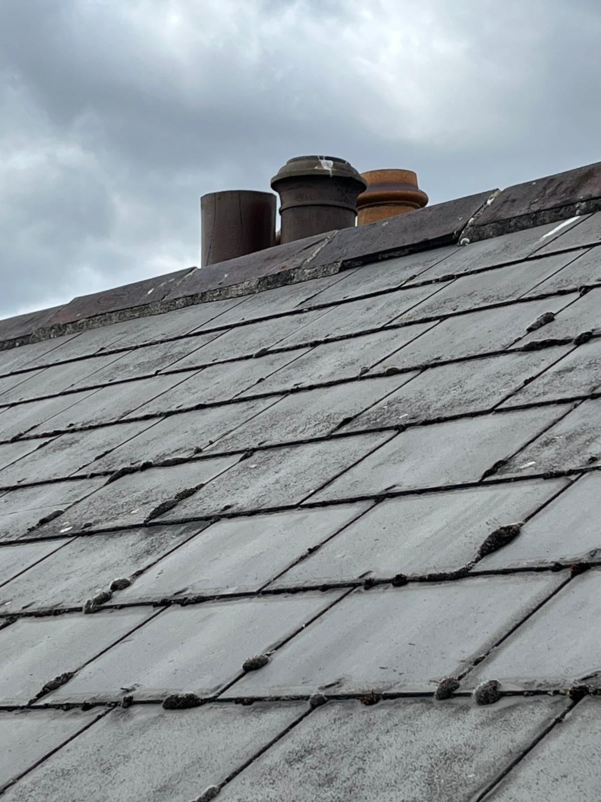 A close up of a roof with chimneys on it.