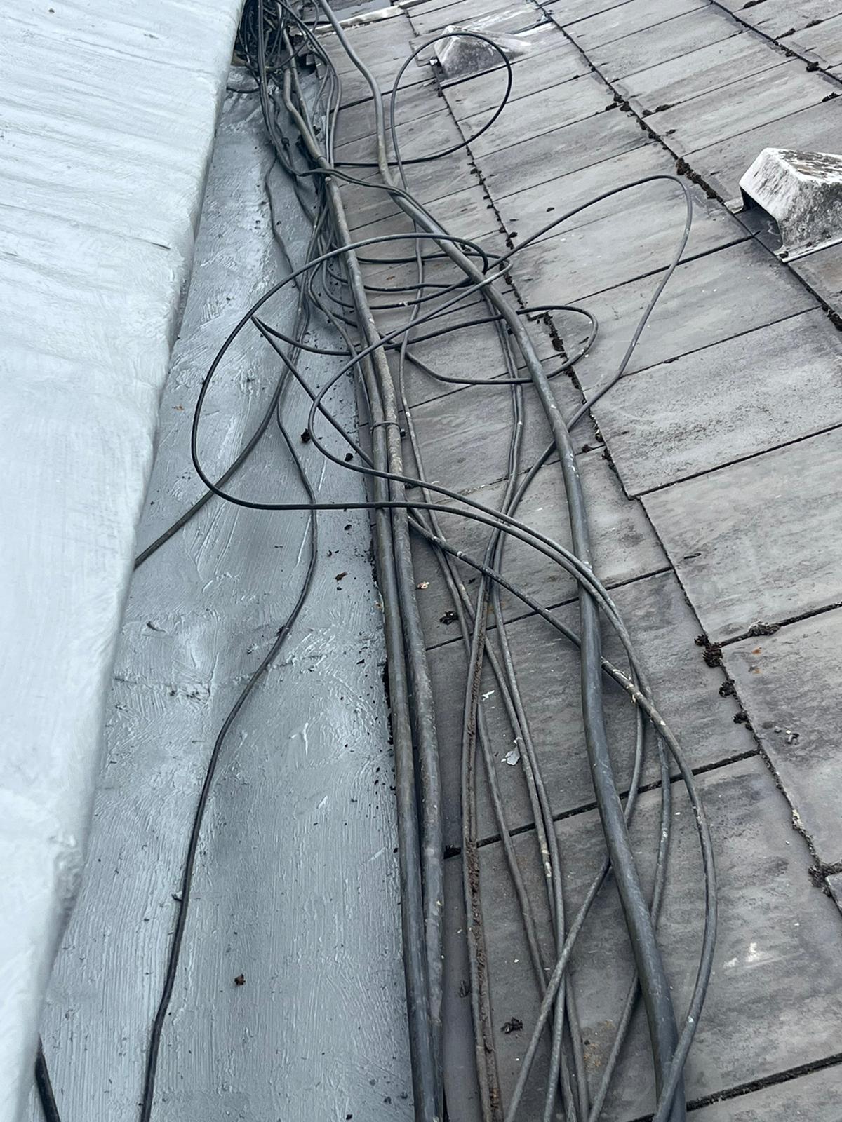 A bunch of wires are laying on a wooden floor.