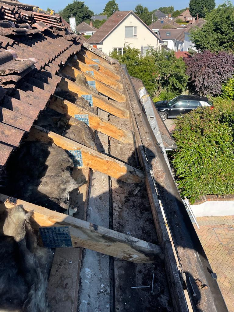 The roof of a house is being repaired and the gutter is being removed.