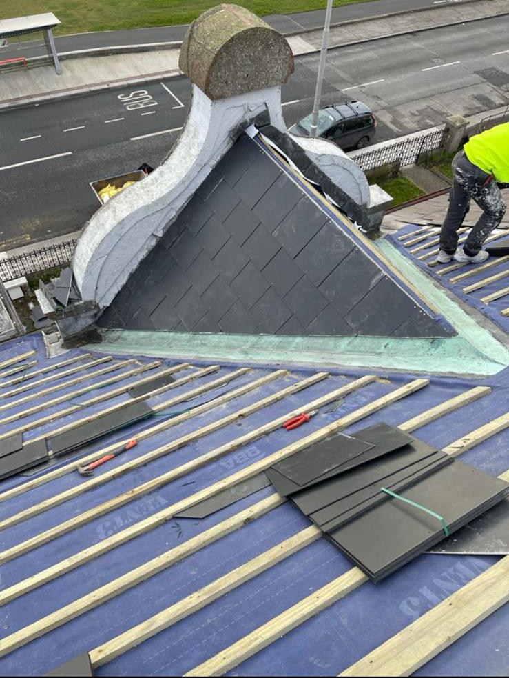 A man is working on the roof of a building.