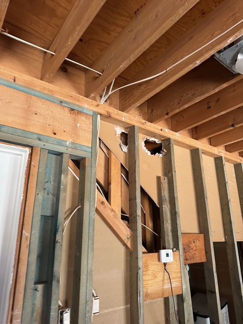 Interior wall under construction showing exposed wood beams and wiring. Interior wall under construction showing exposed wood beams and wiring.